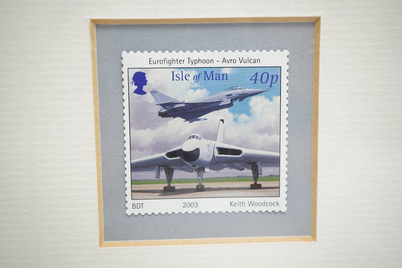 Keith Woodcock, an original gouache painting postage stamp design for an Isle of Man stamp featuring two RAF aircraft from different eras; the Avro Vulcan and the Eurofighter Typhoon, 20cm x 23.5cm, mounted and framed wi
